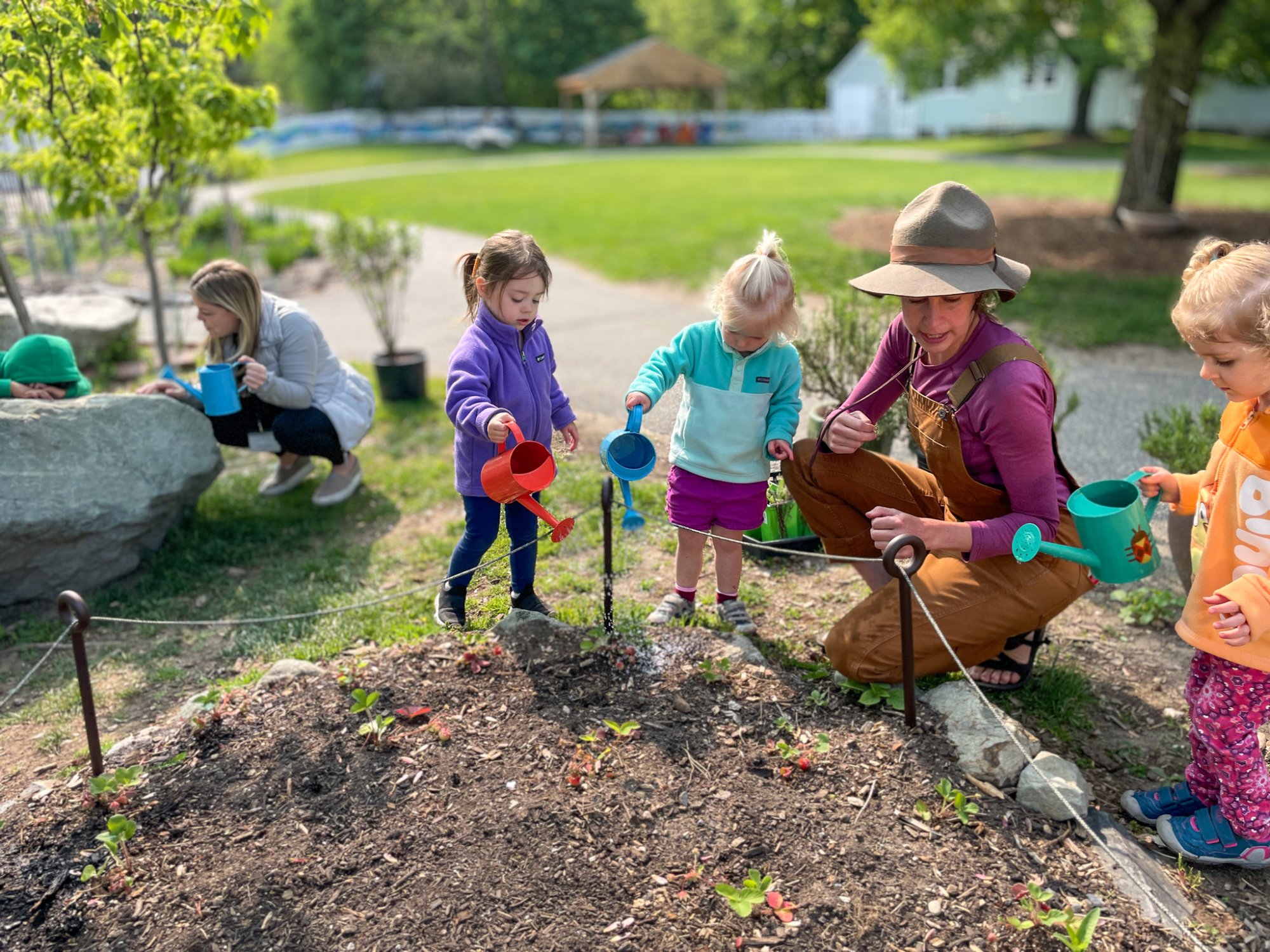 Toddlers watering LMS gardens with our Farming teacher.