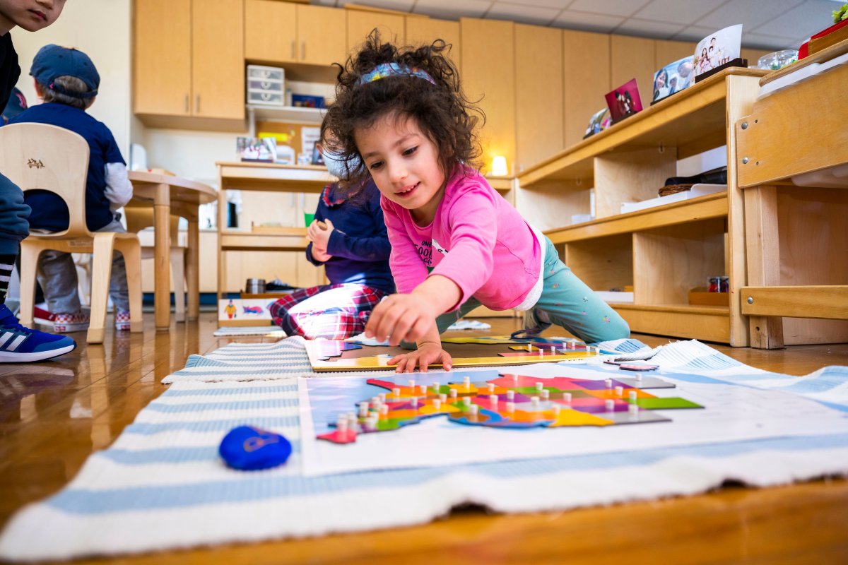 Little girl playing indoors with Montessori materials